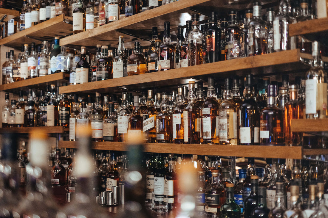 Shelves filled with assorted liquor bottles in a bar or liquor store setting