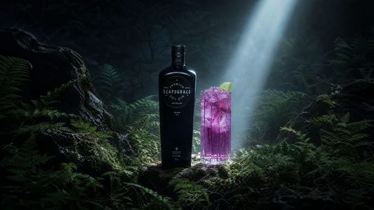 Scapegrace Dry Gin bottle and purple cocktail in misty forest with spotlight