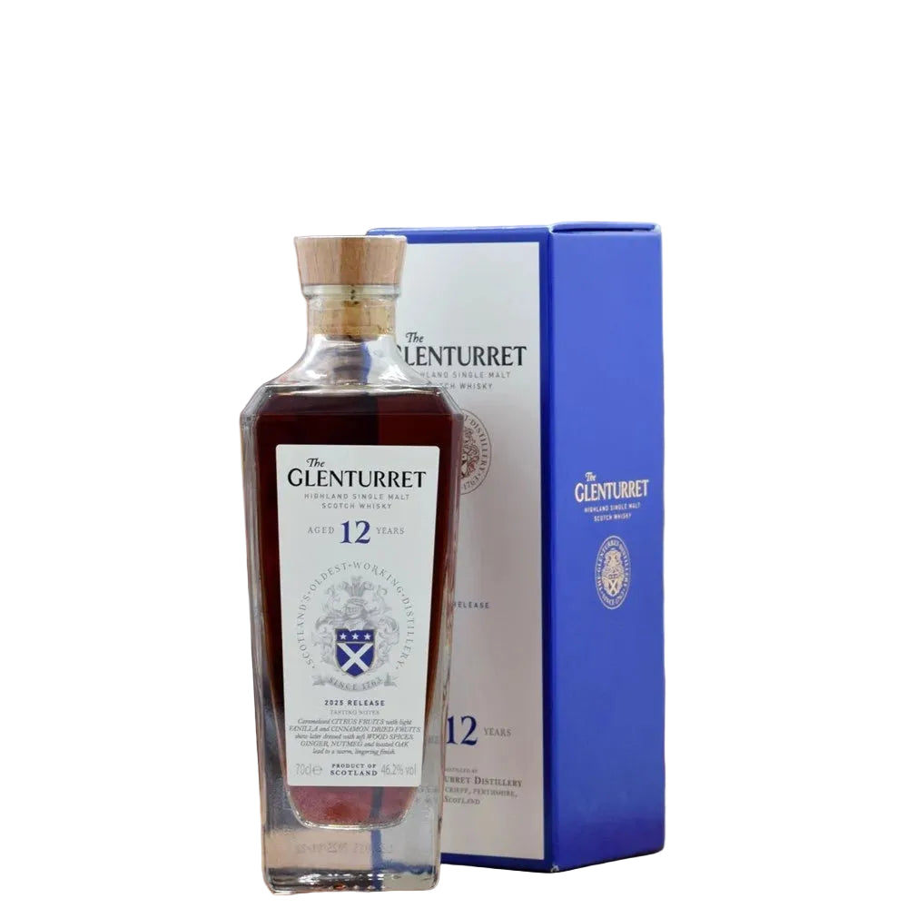 A bottle of The Glenturret 12 Year Old single malt Scotch whisky stands in front of its blue and white packaging box on a wooden surface, with a blurred bar shelf background.